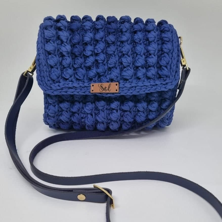 Bolsa Bali azul-royal com aba em ponto pipoca e alça longa tipo couro