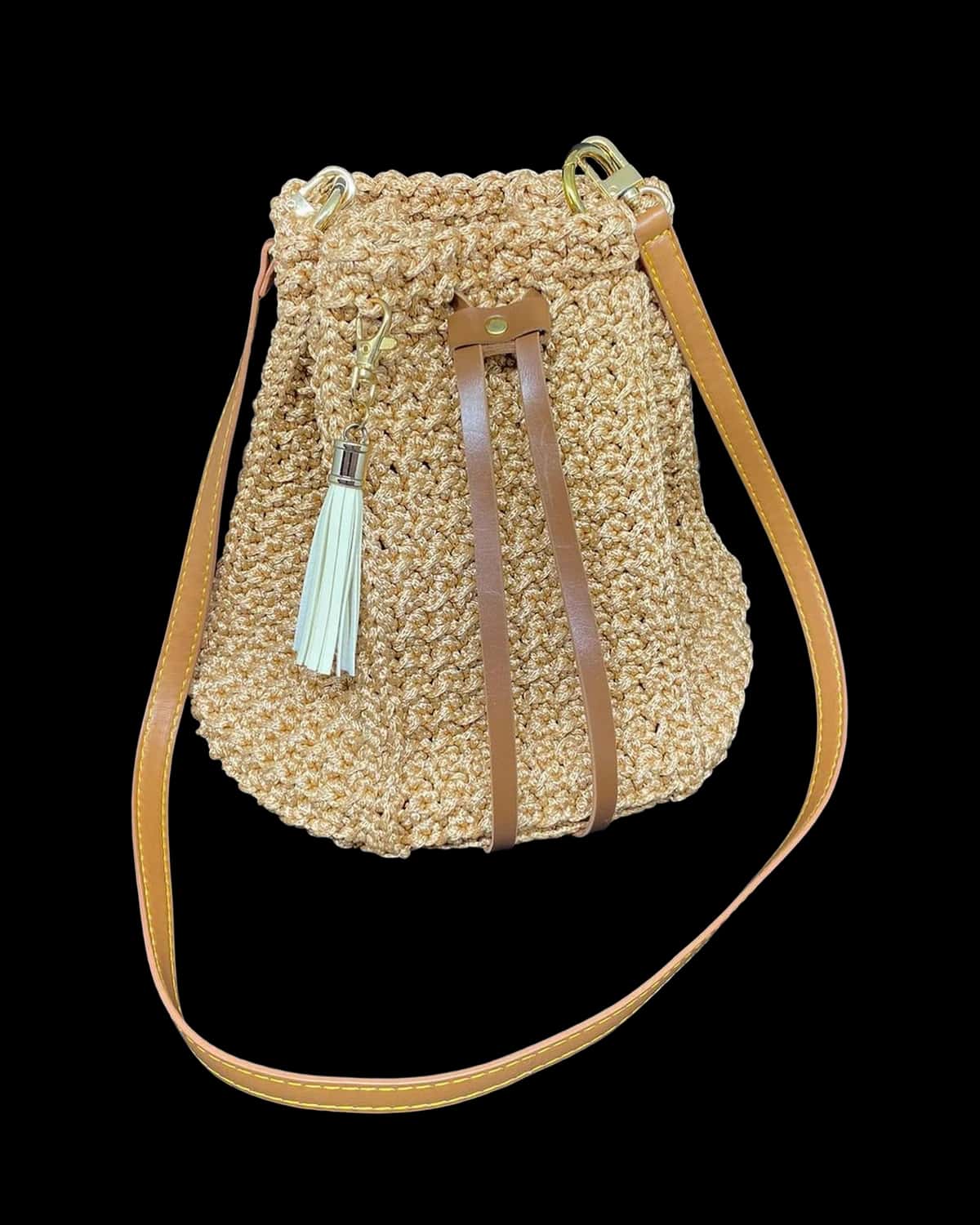 Bolsa saco Caraíva bege dourado com tassel e alça tipo couro caramelo, foto de catálogo em fundo neutro