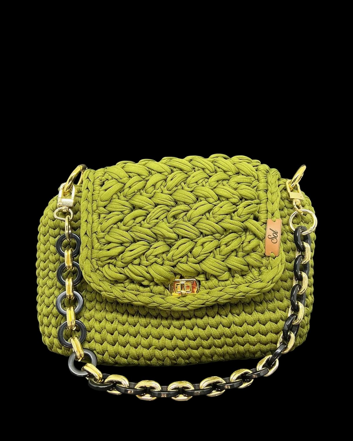 Bolsa Florença verde-oliva com aba trançada, fecho dourado e alça de corrente de elos grandes, foto de catálogo em fundo neutro