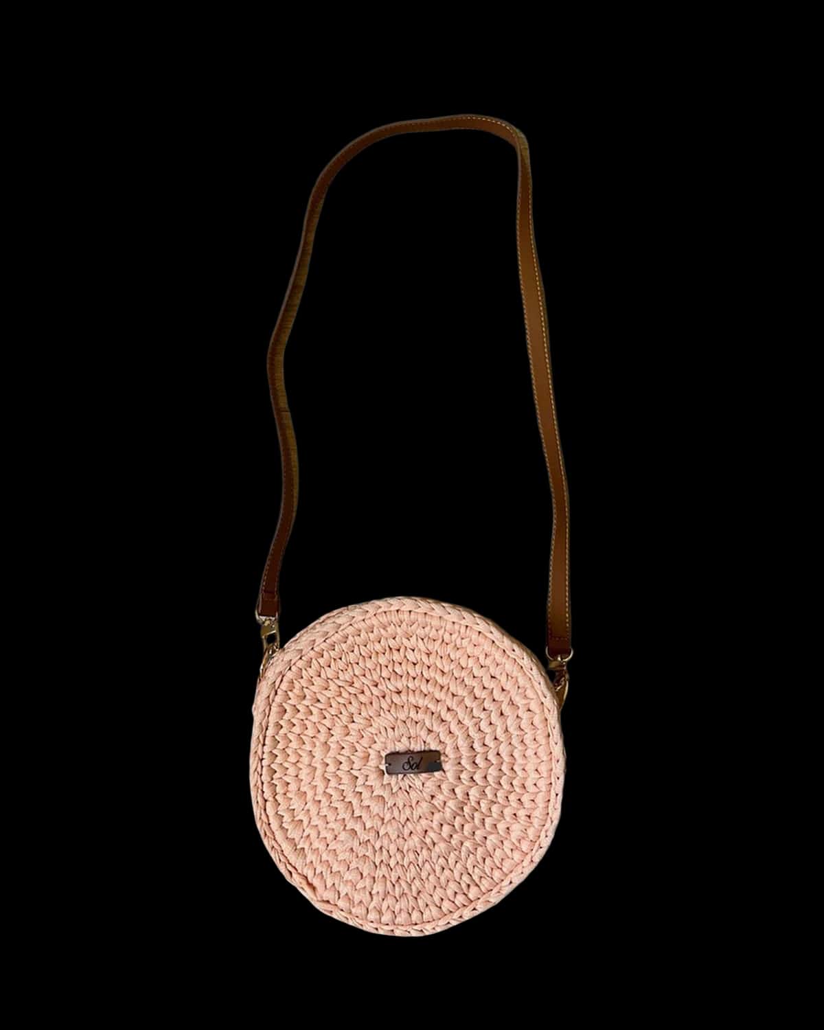 Bolsa Jacarta redonda rosa-claro com alça tiracolo tipo couro marrom, foto de catálogo em fundo neutro