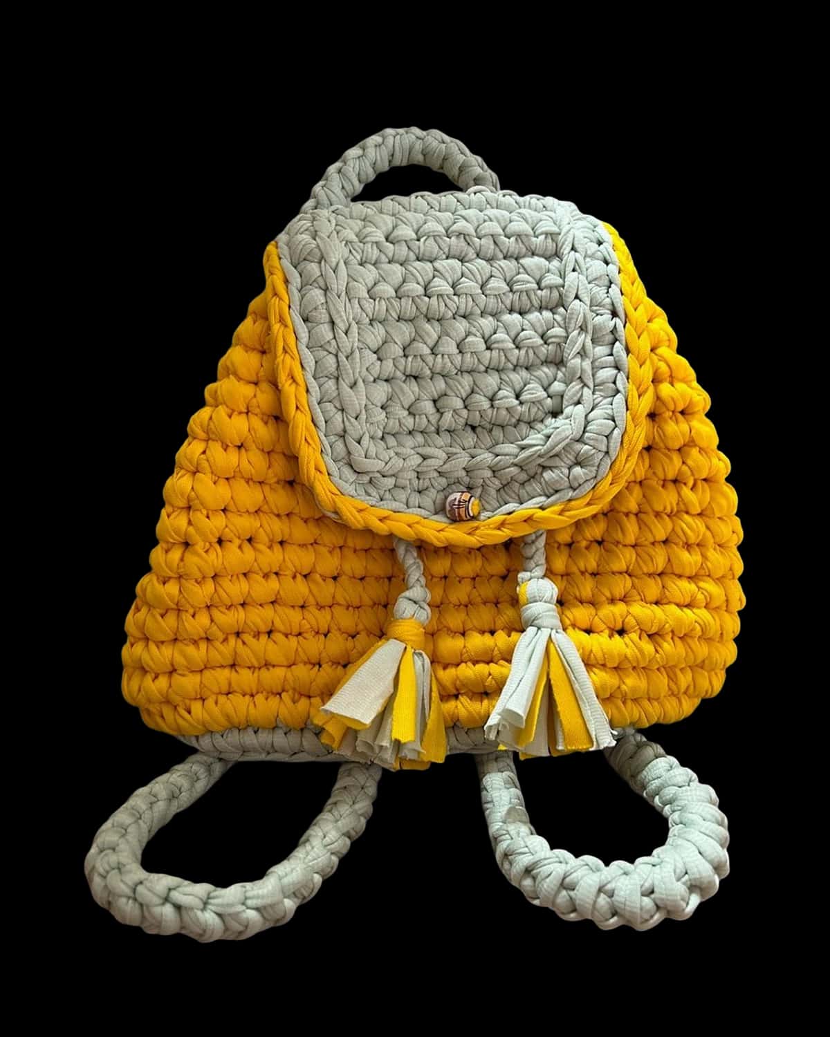 Mochila infantil amarela com aba e alças cinza-claro, foto de catálogo em fundo neutro