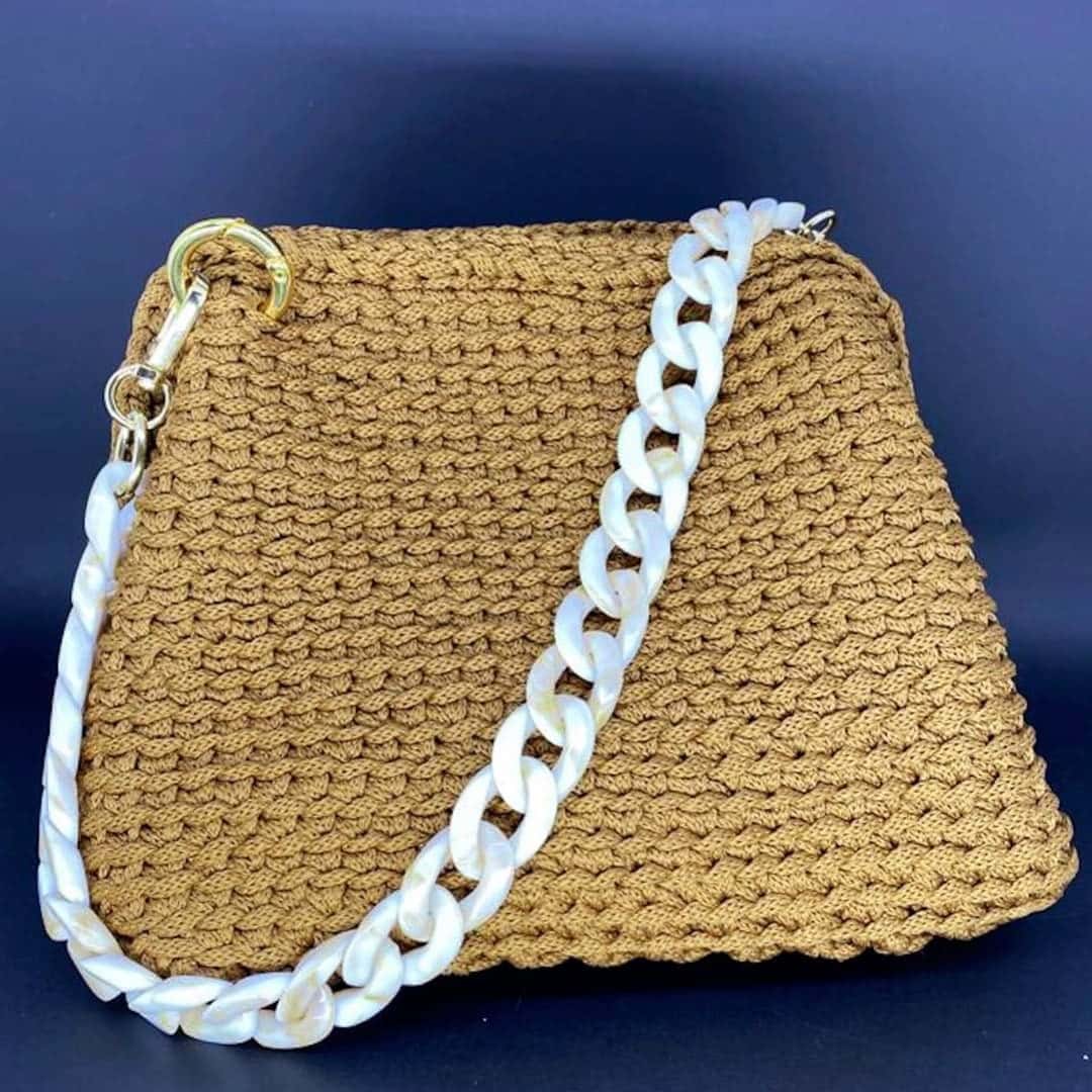 Bolsa Mykonos dourada com alça de elos de acrílico branco perolado