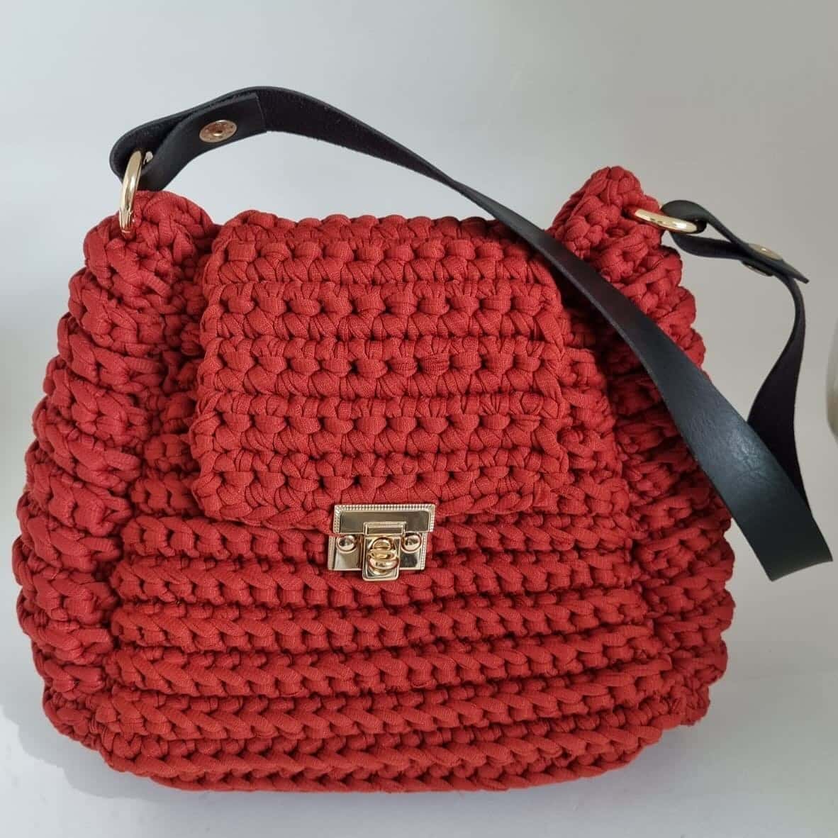 Bolsa Tiradentes na cor canela, em crochê de fio de malha, com fecho dourado e alça tipo couro preto